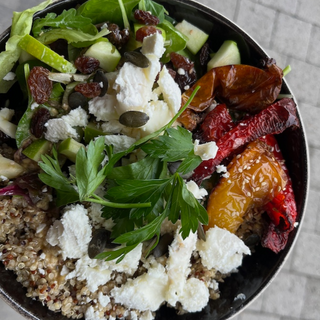 Holi Bowl : trio de quinoa, salade mélangée avec pommes granny et raisins, poivrons rouges et jaunes rôtis aux graines de sésame, émietté de chèvre aux graines de courge 