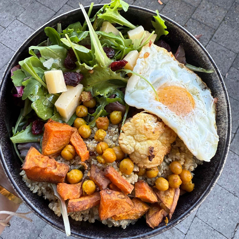 Holi Bowl : Galette de polenta au parmesan et tomates séchées sur lit de salade verte, brocolis, graines de courge et vinaigrette aux herbes